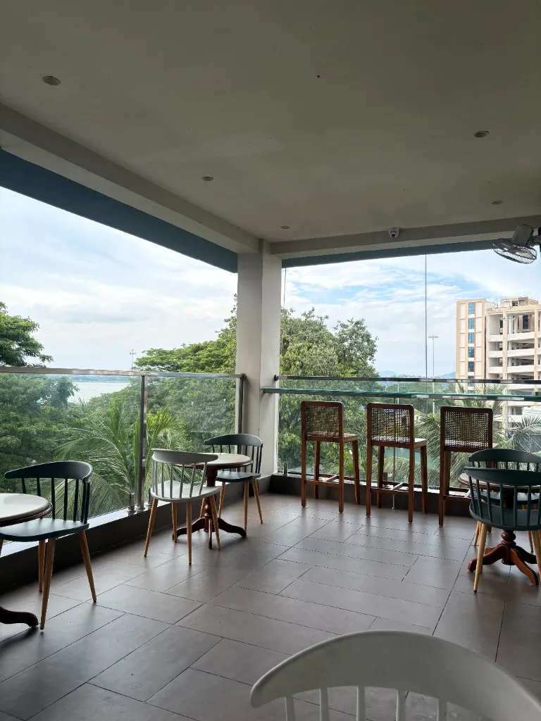 Balcony Seating — Open-air tables above the treetops
